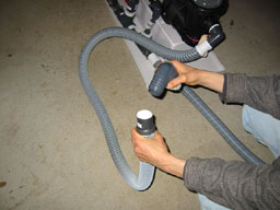 Remove the end of the hose that goes to the pump from the back of the tank. Attach it to a garden hose with the drainage fitting.�